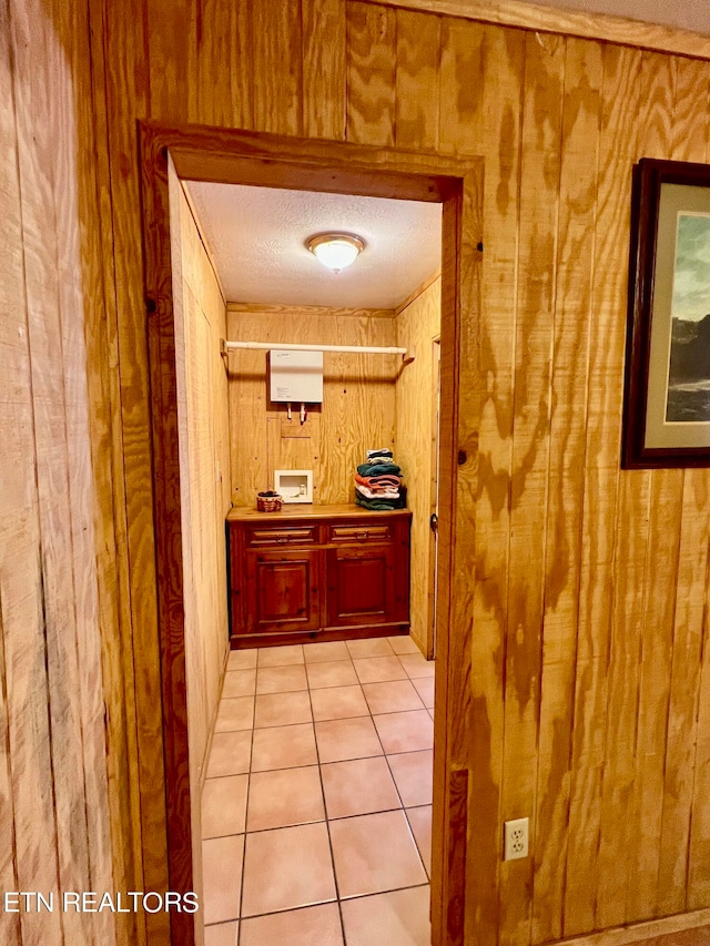 interior space featuring wood walls, a textured ceiling, and tile floors