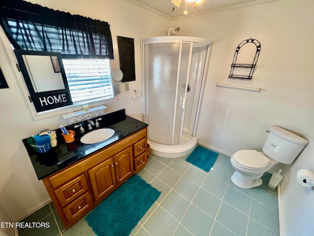 bathroom featuring tile flooring, a shower with door, ornamental molding, toilet, and large vanity