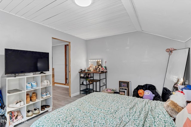 bedroom with hardwood / wood-style floors and lofted ceiling