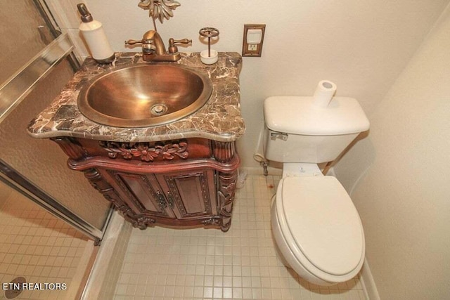 bathroom featuring tile flooring, vanity, and toilet