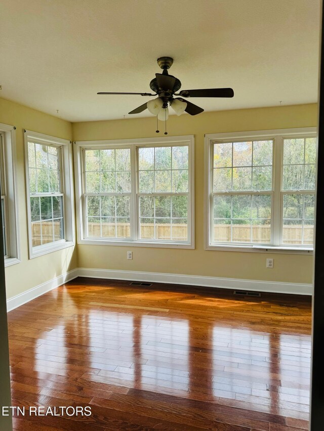 unfurnished sunroom featuring ceiling fan