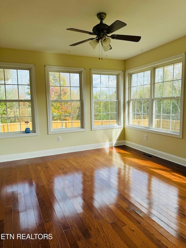 unfurnished sunroom featuring ceiling fan