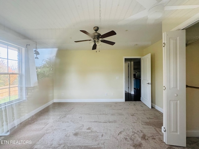 empty room with ceiling fan, wood ceiling, and light colored carpet