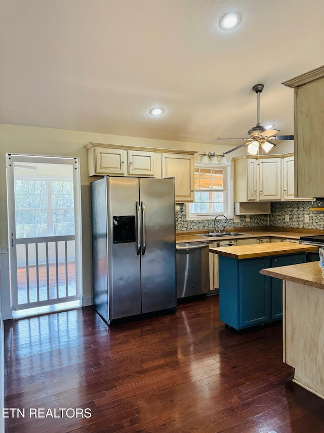 kitchen with dark wood-type flooring, backsplash, appliances with stainless steel finishes, and sink