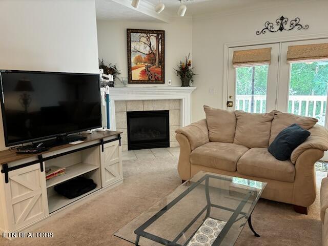 carpeted living room with a tile fireplace