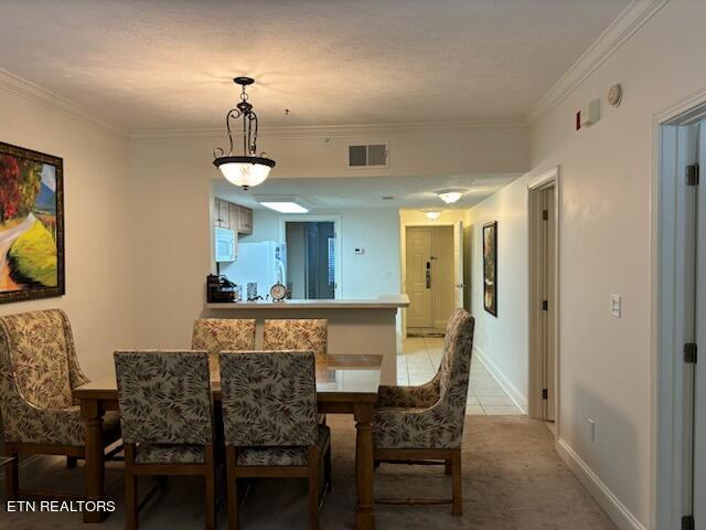 carpeted dining area with crown molding