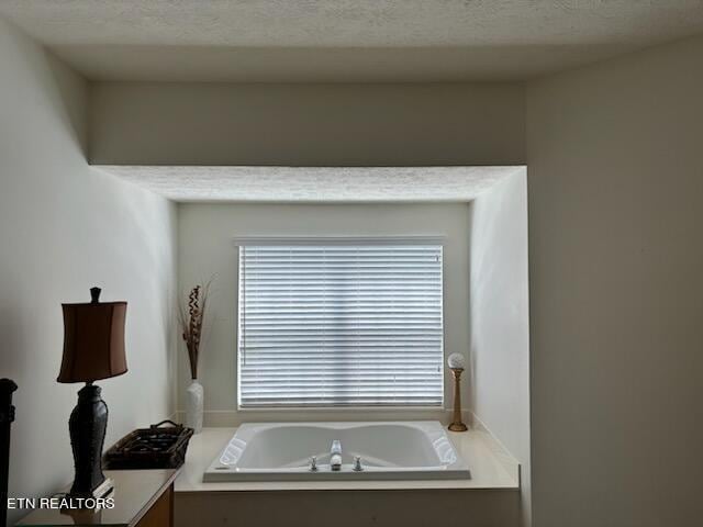 bathroom featuring a washtub and a textured ceiling