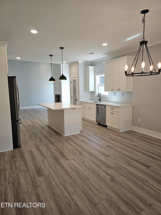 kitchen with a kitchen island, stainless steel appliances, dark wood-type flooring, hanging light fixtures, and white cabinetry