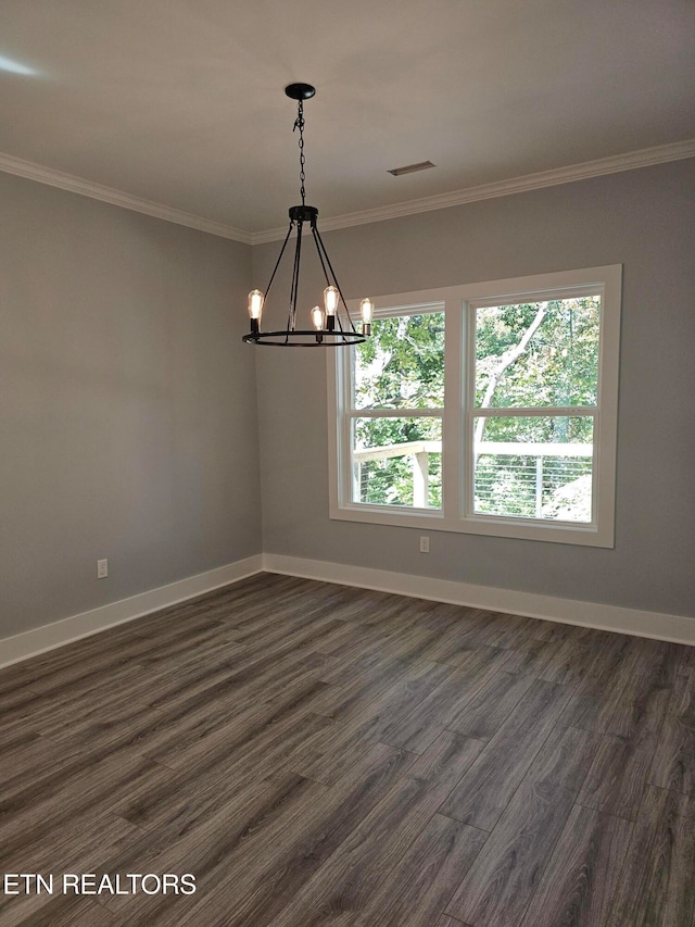 unfurnished room featuring dark wood-type flooring, ornamental molding, an inviting chandelier, and a wealth of natural light