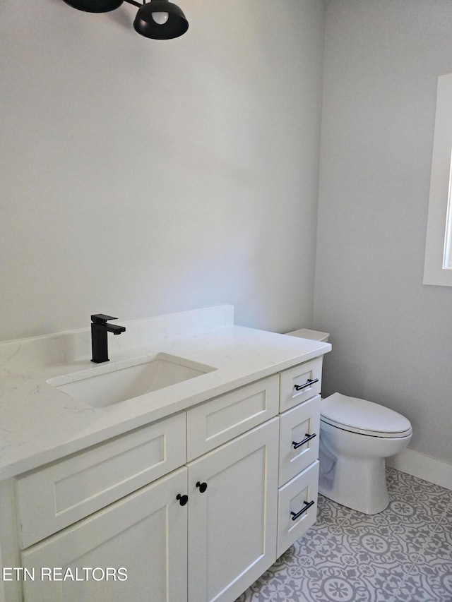 bathroom with tile patterned flooring, vanity, and toilet