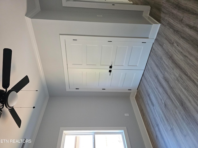 interior space with ceiling fan and tile walls