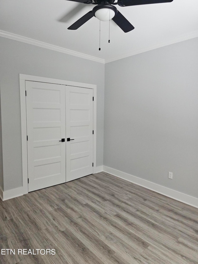 unfurnished bedroom featuring ornamental molding, light wood-type flooring, and ceiling fan