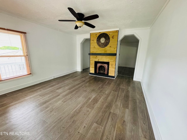 unfurnished living room with wood-type flooring, ceiling fan, a textured ceiling, and a fireplace