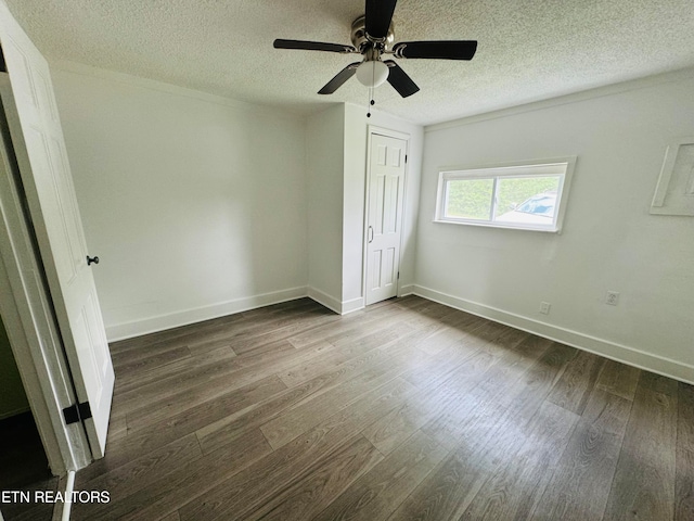 unfurnished bedroom featuring ceiling fan, a closet, a textured ceiling, and dark wood-type flooring