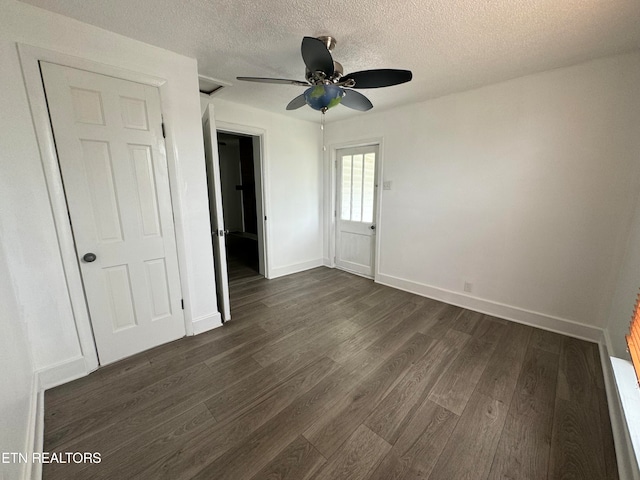 unfurnished bedroom featuring a textured ceiling, dark hardwood / wood-style floors, and ceiling fan