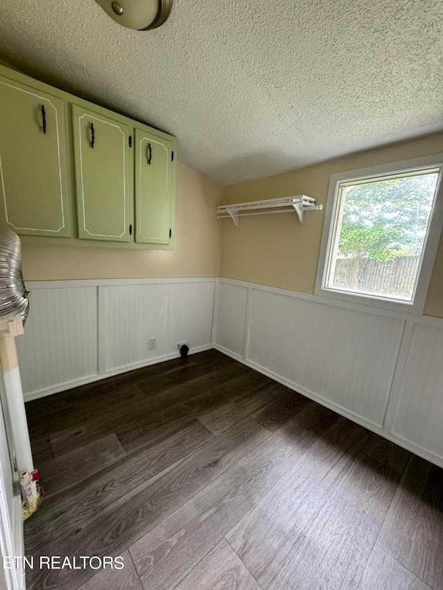 unfurnished room with a textured ceiling and wood-type flooring