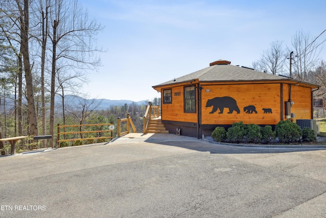 view of side of property featuring a mountain view and central AC