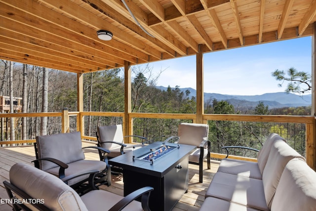 wooden deck featuring an outdoor living space with a fire pit and a mountain view