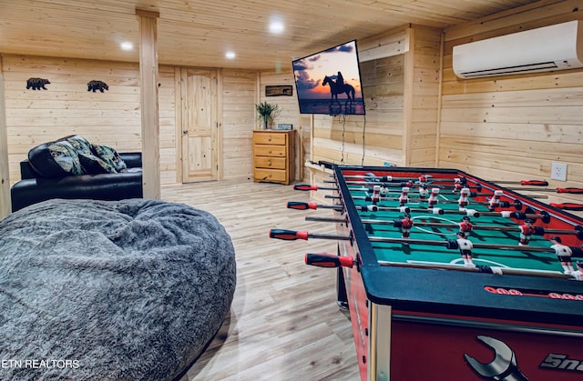 playroom featuring wooden ceiling, wood-type flooring, wooden walls, and a wall mounted air conditioner