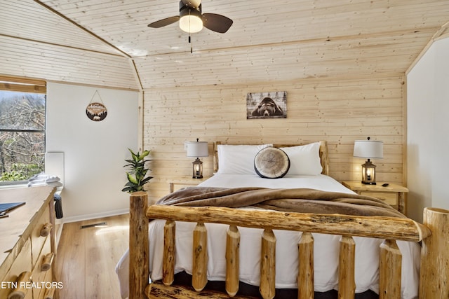 bedroom with light wood-type flooring, wood ceiling, lofted ceiling, and wood walls