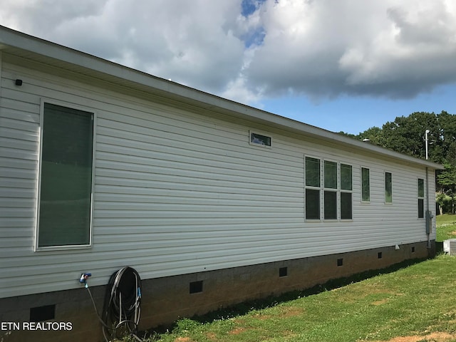 view of side of home with a yard and central air condition unit