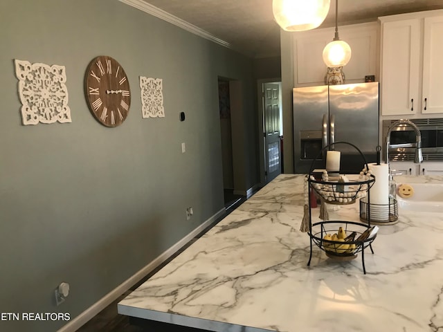 kitchen featuring decorative light fixtures, light stone counters, stainless steel fridge with ice dispenser, crown molding, and white cabinetry