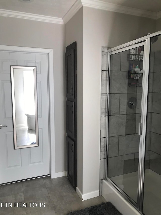 bathroom with tile floors, ornamental molding, and a shower with shower door