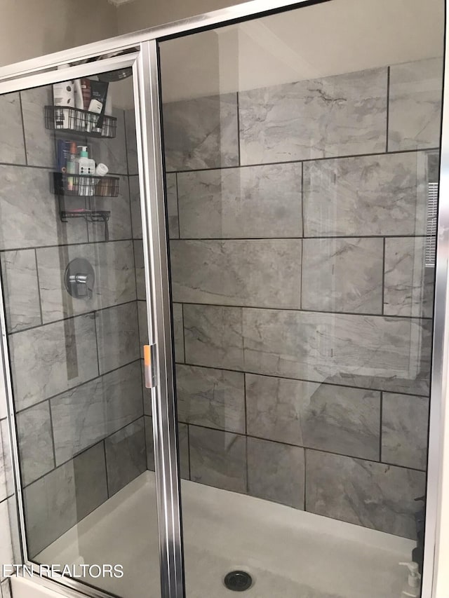 bathroom featuring a shower with door