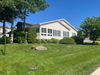 view of side of home with a yard