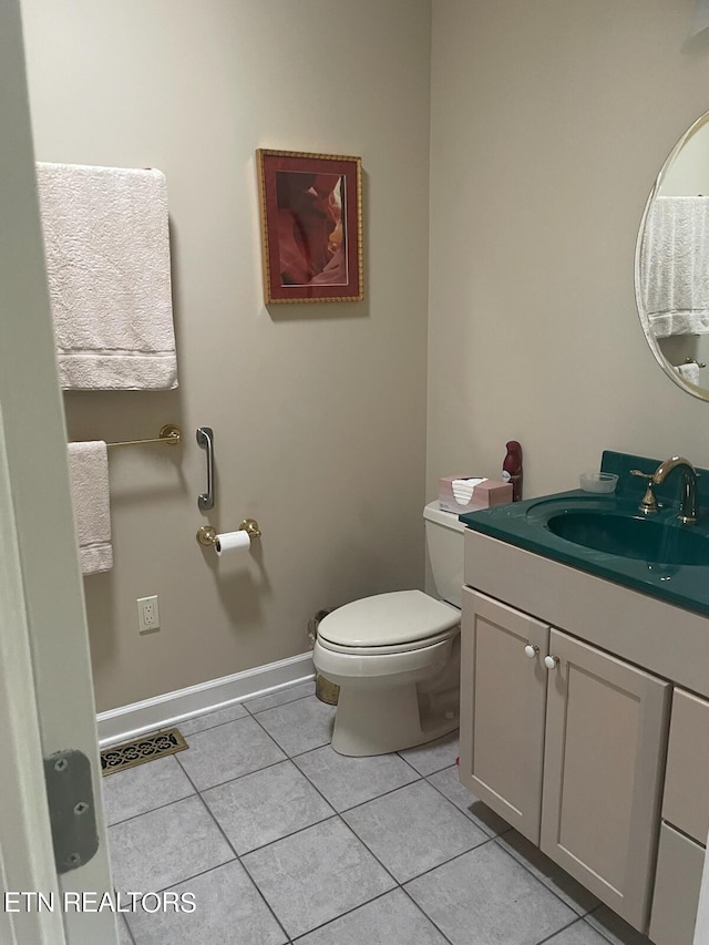 bathroom with tile flooring, vanity, and toilet