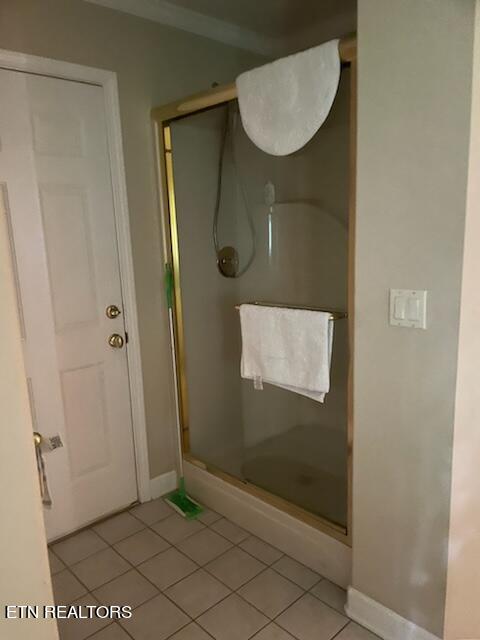 bathroom featuring tile floors and an enclosed shower