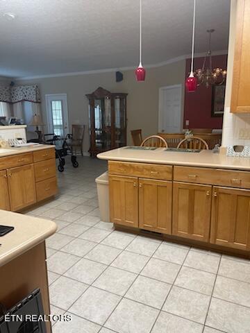 kitchen featuring crown molding, light tile floors, and pendant lighting