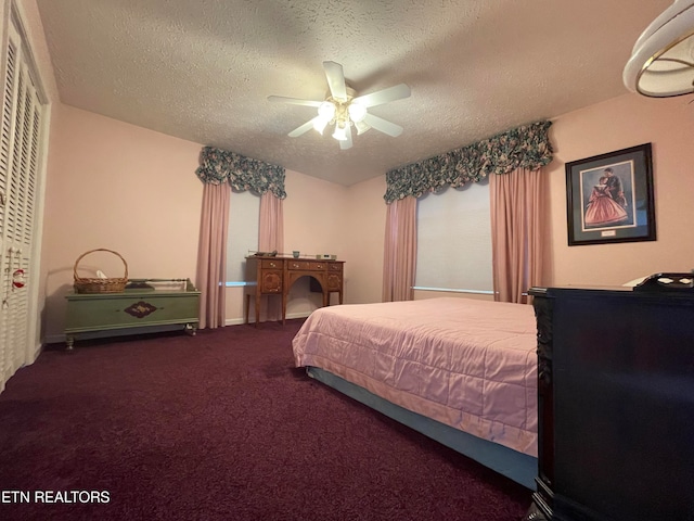 carpeted bedroom with a closet, ceiling fan, and a textured ceiling