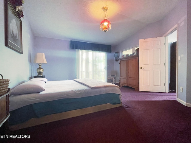 bedroom with a notable chandelier, vaulted ceiling, and carpet floors