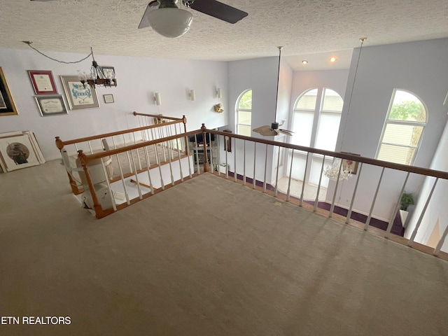 hallway featuring a textured ceiling and carpet flooring