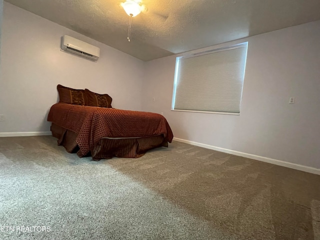 bedroom featuring carpet, a textured ceiling, and a wall mounted air conditioner