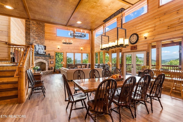 dining room with a healthy amount of sunlight, wood-type flooring, and wooden walls