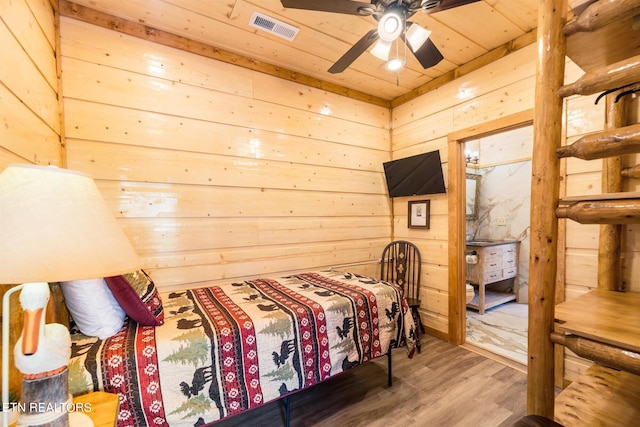 bedroom with wooden ceiling, ceiling fan, wooden walls, and wood-type flooring