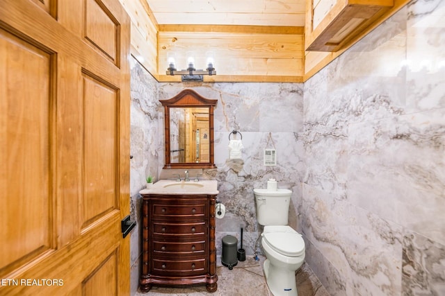 bathroom featuring tile flooring, tile walls, toilet, and vanity