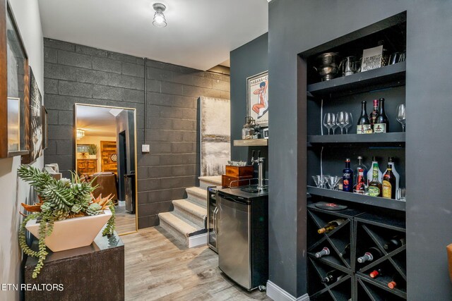 interior space featuring bar and light hardwood / wood-style floors