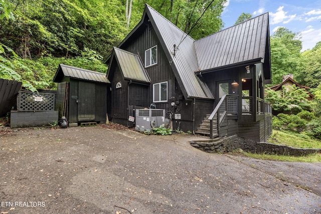 view of front of house featuring central AC and a storage shed