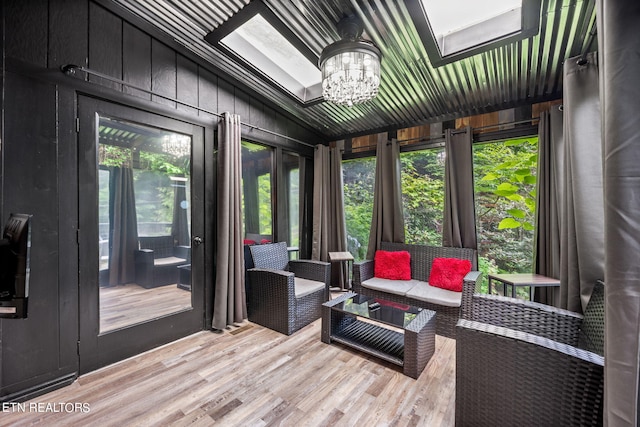 sunroom with lofted ceiling with skylight and a chandelier