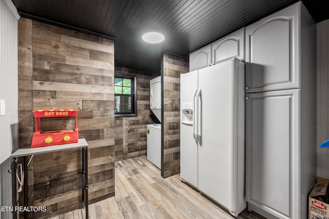 kitchen with stacked washer / dryer, light wood-type flooring, white fridge with ice dispenser, wood walls, and wood ceiling