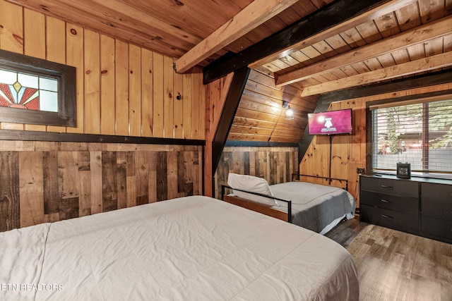 bedroom with wood walls, lofted ceiling with beams, hardwood / wood-style flooring, and wood ceiling