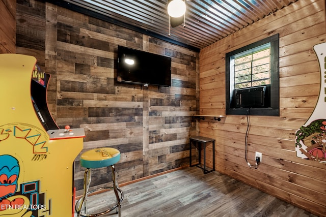 game room with wooden walls and hardwood / wood-style floors