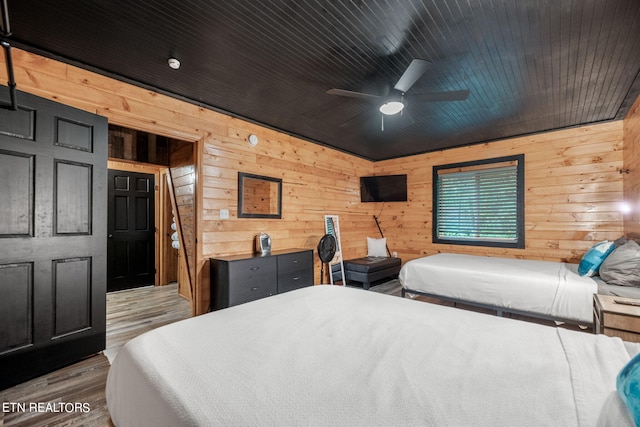 bedroom featuring wooden walls, ceiling fan, hardwood / wood-style floors, and wood ceiling