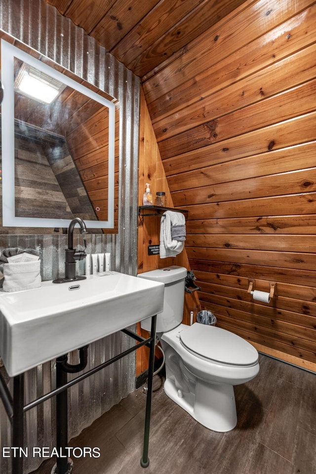 bathroom with vaulted ceiling, wood-type flooring, wood walls, toilet, and wooden ceiling