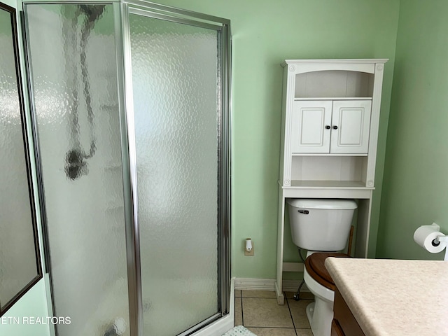 bathroom featuring tile patterned floors, vanity, toilet, and an enclosed shower