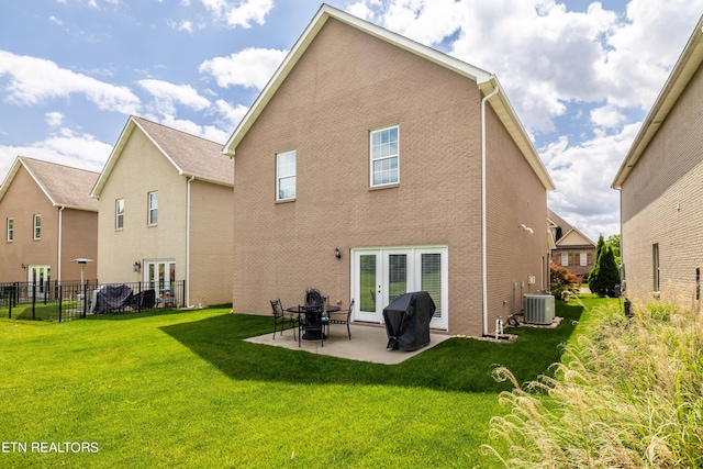 back of house with a patio area, a lawn, french doors, and central air condition unit