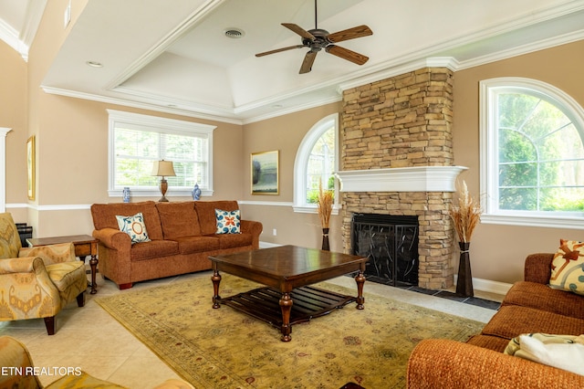 living room featuring ceiling fan, crown molding, a fireplace, and a raised ceiling